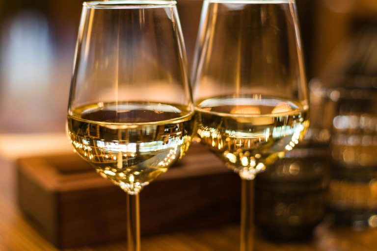 two glasses of white wine on a table